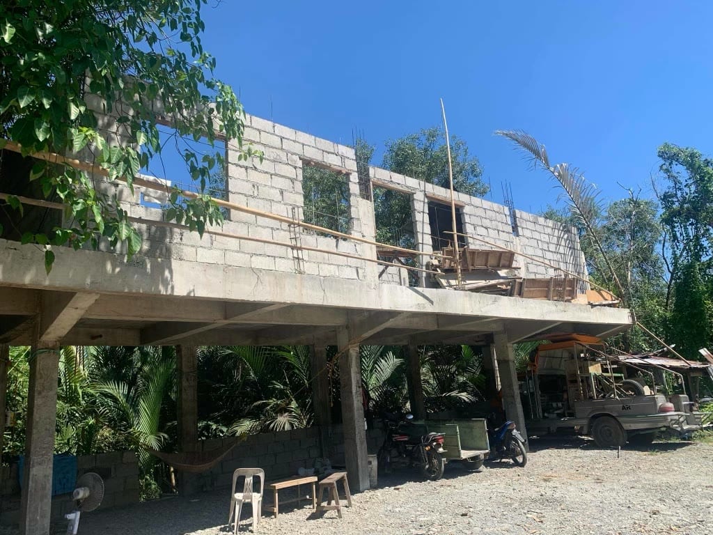 The concrete frame standing on its posts with the first courses of blockwork on the elevated slab